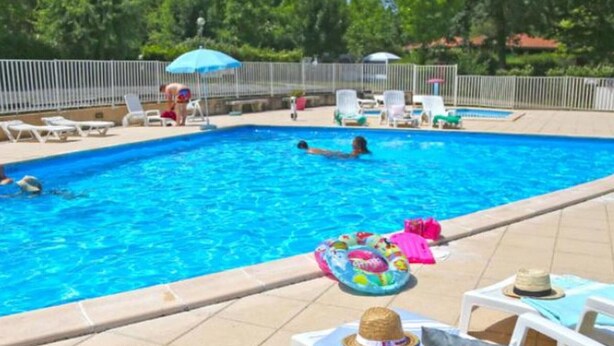 Une piscine avec des chaises longues et des parasols.