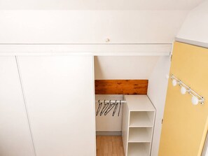 Ein Schlafzimmer mit Kleiderschrank, einem Bett und einer kleinen Sitzecke.