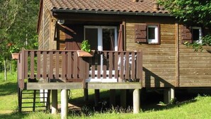 A wooden cabin with a porch and a small window. - Cozy chalet with terrace - 6 guests (Thiviers)