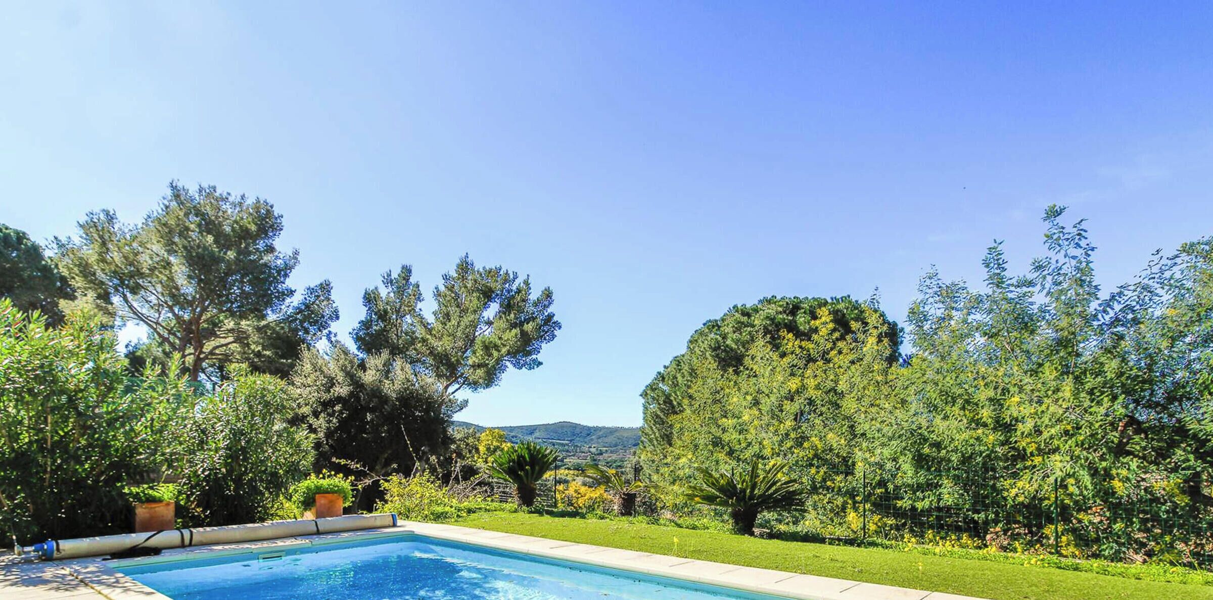 A swimming pool with a view of trees and hills.