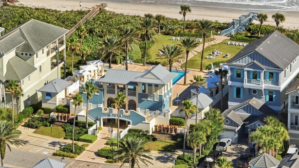 Zona residencial costera con casas, una playa y una piscina.