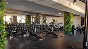 A gym with weightlifting equipment, treadmills, and dumbbells. - Luxe 2BR Retreat 5-Min PATH to NYC With Rooftop+Gym (Jersey City)