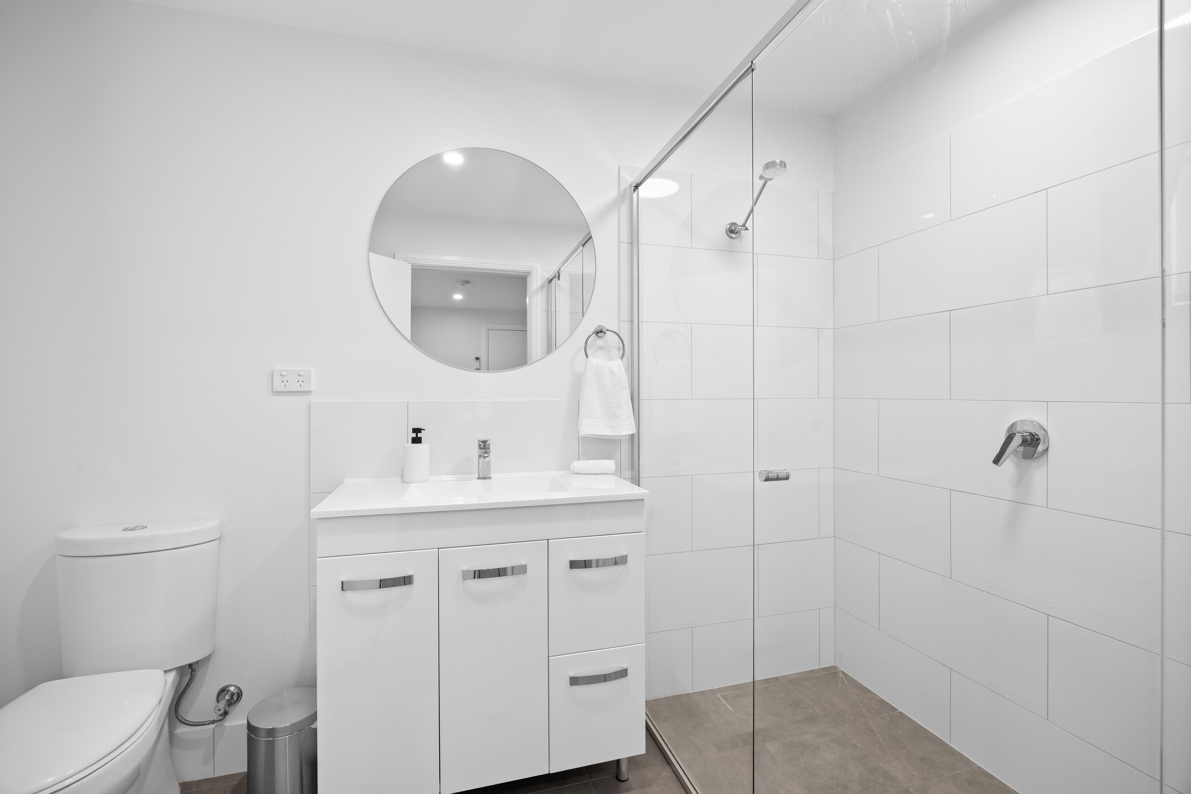 A modern bathroom with a toilet, sink, and shower.