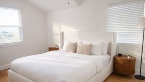 A bedroom with a large bed, a bedside table, a floor lamp, and a window with blinds. - Skyline View Home w/ Office - Minutes From Culver, LAX, Santa Monica & SOFI (Los Angeles)