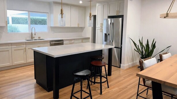 A modern kitchen with a large island, stainless steel appliances, and wooden flooring. - Skyline View Home w/ Office - Minutes From Culver, LAX, Santa Monica & SOFI (Los Angeles)