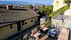A rooftop terrace with outdoor seating, a city skyline in the background, and a view of mountains. - Skyline View Home w/ Office - Minutes From Culver, LAX, Santa Monica & SOFI (Los Angeles)