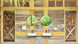 A wooden wall with two sinks and two mirrors.