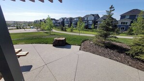 Un barrio residencial con casas modernas, un patio empedrado y una pequeña mesa de madera.
