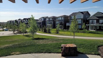 Una zona residencial con casas modernas, un césped cuidado y una cancha de baloncesto.