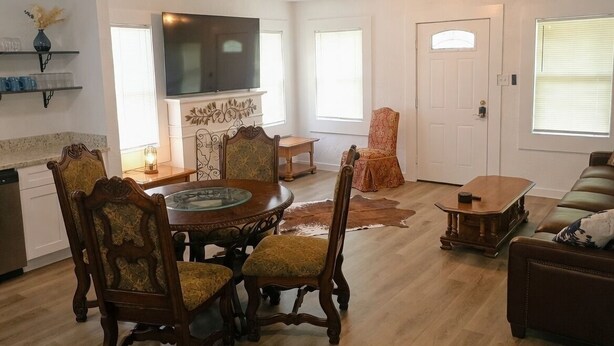 A dining area with a round table, chairs, a television, and a fireplace. - Saddle Up at Rodeo Ranch House! Cowboy Vibes, Blocks from the Stockyards Action! (Fort Worth)