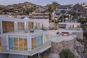 Um resort moderno com piscina, área de estar ao ar livre e vista para a paisagem circundante.