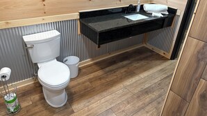 Une salle de bain avec des toilettes, un lavabo et un lambris en bois.