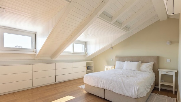 A bedroom with a sloped ceiling, a bed, a nightstand, and built-in storage. - Casa do Limoeiro 4-bdr house in a quiet square, 10 min walk from Cascais center. (Cascais)