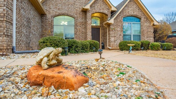 A brick house with a stone sculpture in the front yard. - Hill Country | Spacious 4BR Retreat (Abilene)