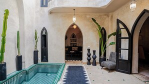 A Moroccan-style interior with a tiled fountain, cacti, and a patterned rug. - Authentic Marrakech Riad in the Heart of the Medina (Marrakesh)