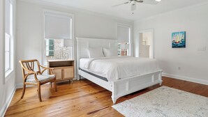 A bedroom with a bed, a chair, a desk, and a ceiling fan. - Savannah Home, Sleeps 6, Prime Location (Savannah)