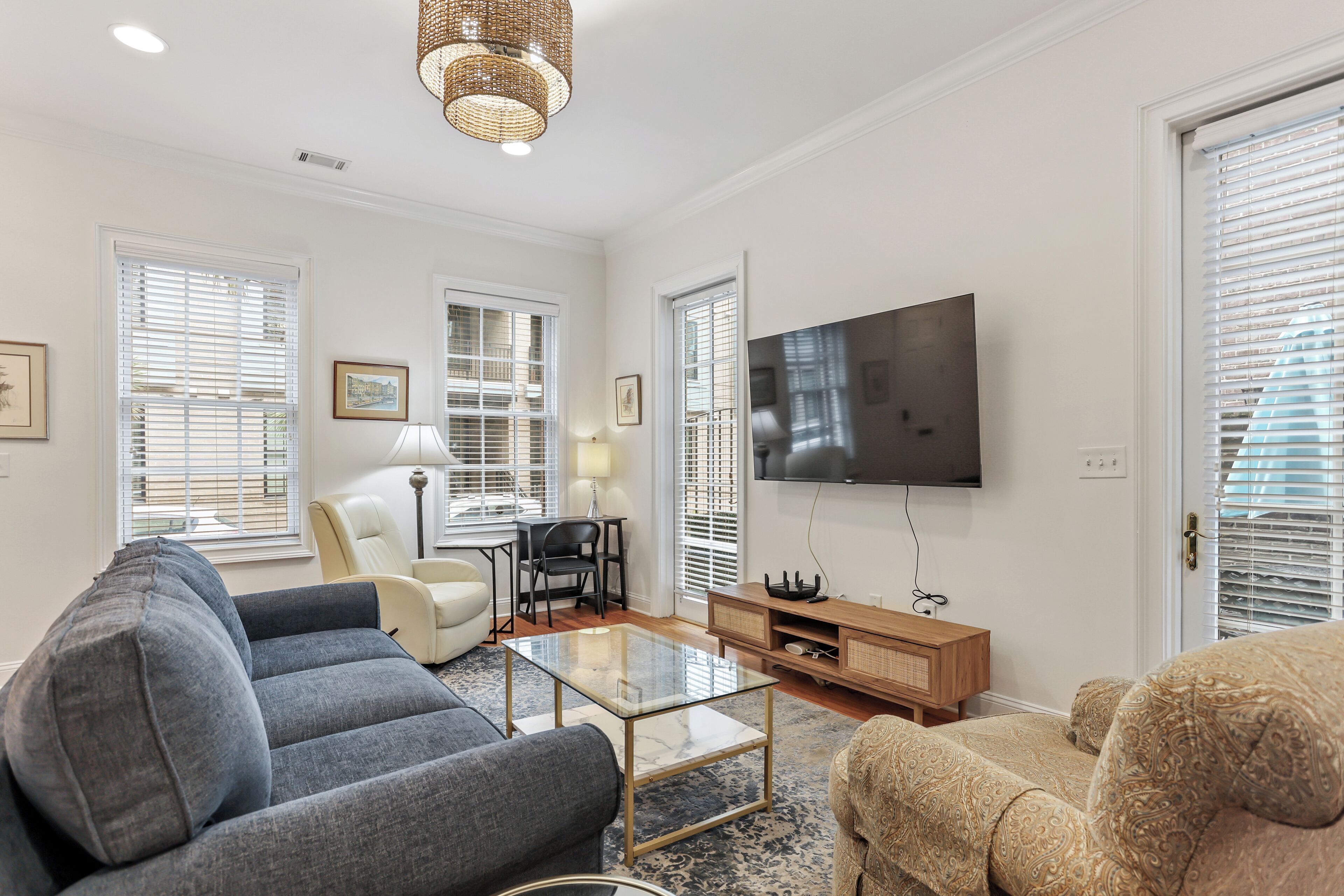 A modern living room with a sofa, armchair, coffee table, and TV.