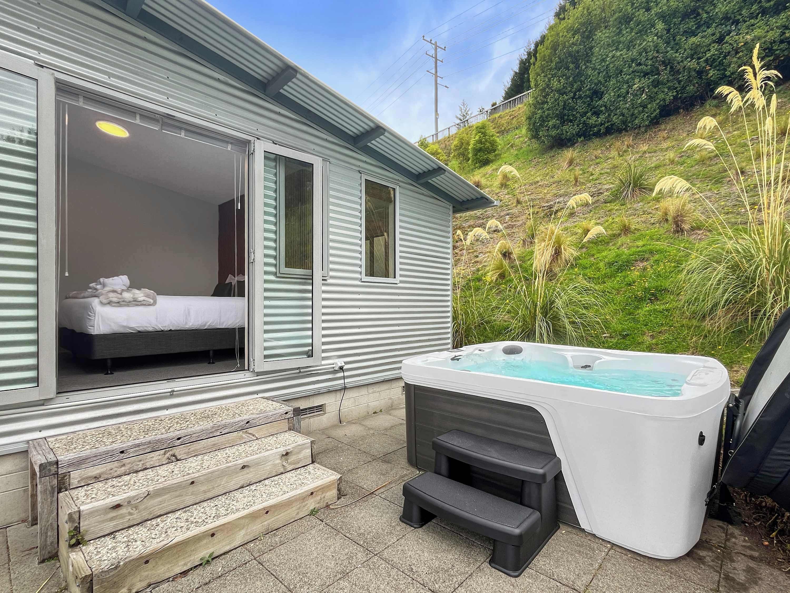 Une chambre d’hôtel avec un lit, une fenêtre et un jacuzzi.