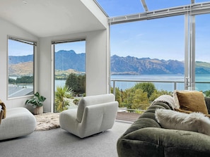 A modern living room with a large window offering a mountain view.