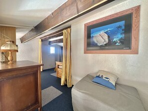 A cozy room with a wooden desk, a lamp, a bunk bed, a sofa with a cushion, and a framed picture on the wall. - CAP D'AGDE - Plage Richelieu / Réf 0156 (CAP D'AGDE)