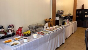 A buffet table with various food items and a coffee station. - Camino real (Puno)