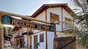 A rustic building with a sign reading "RESERVA SETRA" and a wooden gate. - Pousada Reserva Setiba (Guarapari)