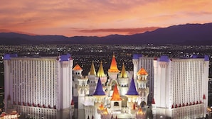 A large hotel with multiple towers and a reflective pool in front.