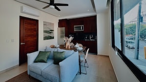 A modern living room with a sofa, dining table, and kitchen area. - OVATA TH-1/1 BR/Rooftop con Alberca/Zona Romántica (Puerto Vallarta)