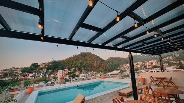A rooftop pool area with a view of a hillside town. - OVATA TH-1/1 BR/Rooftop con Alberca/Zona Romántica (Puerto Vallarta)