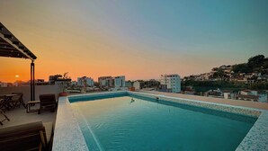 A rooftop pool with a tiled edge, surrounded by lounge chairs and a pergola. - OVATA TH-1/1 BR/Rooftop con Alberca/Zona Romántica (Puerto Vallarta)