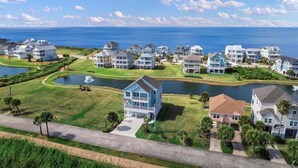 Un quartier résidentiel situé sur la côte, avec des maisons, un lac et une vue dégagée sur l’océan.
