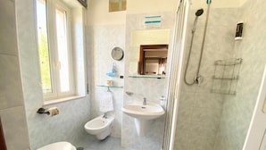 A bathroom with a toilet, bidet, sink, and shower. - Hotel Praja Mare (Praia a Mare)