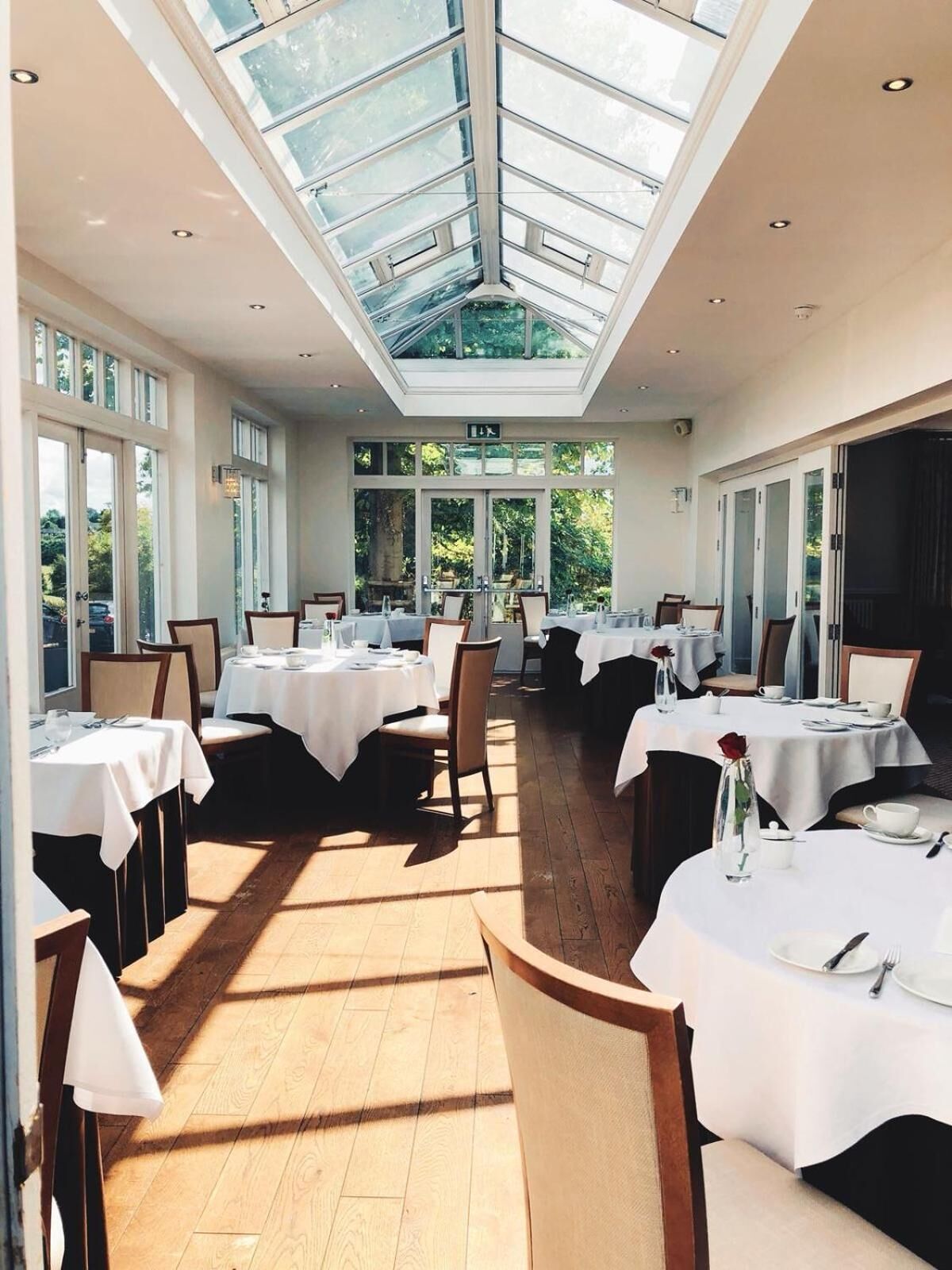 A spacious dining area with high ceilings and large windows, allowing natural light to fill the space.