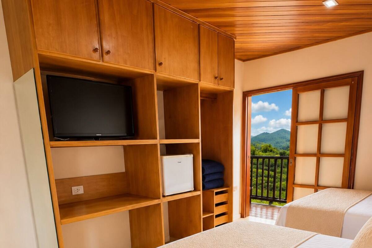 Ein Schlafzimmer mit einem Bett, einem Fernseher und einem Kleiderschrank.