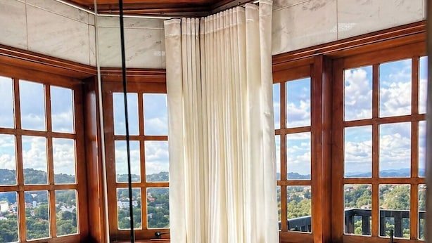 A hot tub with a view of a landscape through large windows. - Pousada Chateau Elegance (Campos do Jordão)