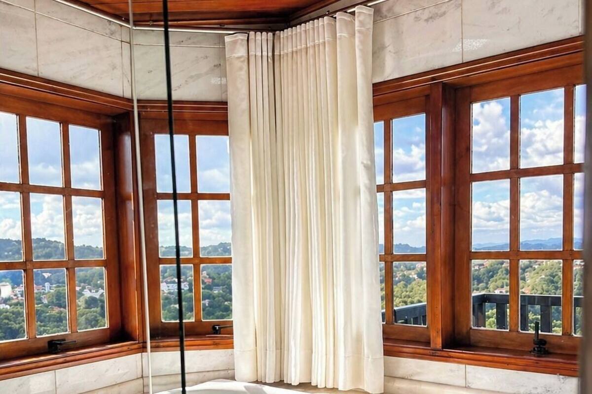 Ein Whirlpool mit Blick auf eine Landschaft durch große Fenster.