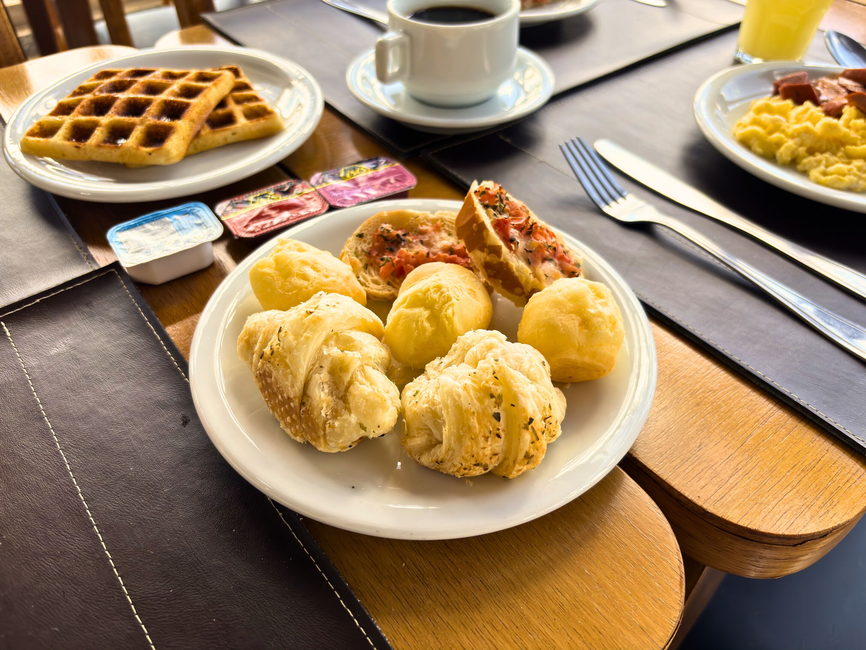 Ein Frühstückstisch mit Waffeln, Croissants und Rührei.