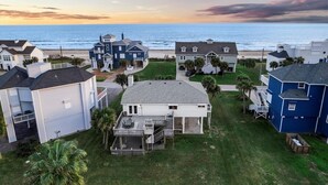 A coastal residential area with houses, a beach, and a sunset. - Beachview | Fire Pit | Cargo Lift | Pet-Friendly | Steps to Shore (Galveston)