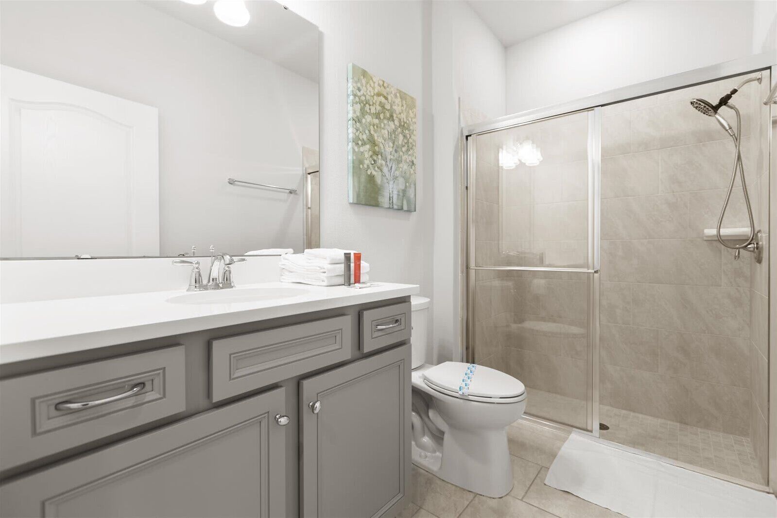 A modern bathroom with a shower, toilet, and vanity.
