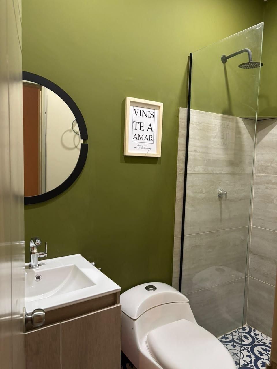 A bathroom with a toilet, sink, and shower.