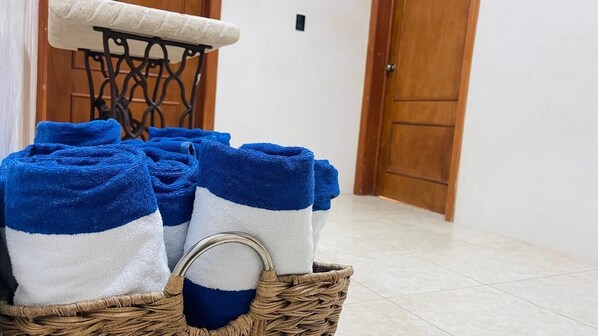 A wicker basket filled with blue and white towels.