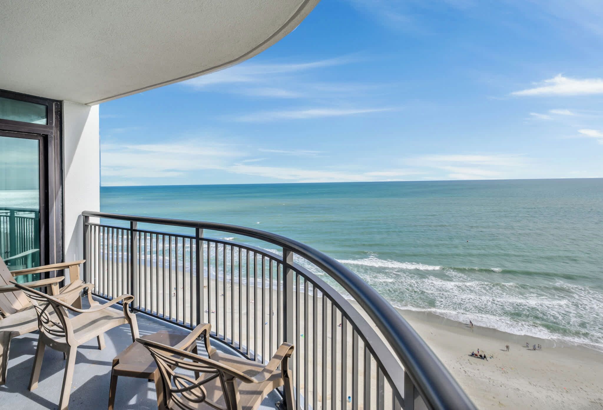 A balcony with a view of the ocean and beach.