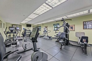 Ein Fitnessstudio mit verschiedenen Trainingsgeräten, darunter Laufbänder und Gewichte.