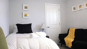 A bedroom with a bed, a black sofa, and a door. - Walk /Funny Bone Comedy Club, Dining, Shopping, Free parking, Free Coffee, Patio (Dayton)