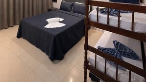 A hotel room with a large bed, a smaller bed, a wooden headboard, a nightstand, and a window with curtains. - POUSADA MARÉ DE ENCANTOS (Penha)