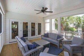 A covered porch with a ceiling fan, a sofa set, and a dining table. - Grand Opening June 13! New 6BR/5.5 Bath Luxury - Sleeps 18 - 4 rows to the Beach (Hilton Head Island)