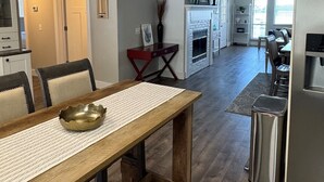 Een ruime keuken met een eethoek, houten vloeren en moderne apparatuur.