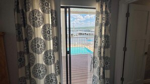 Een kamer met uitzicht op een zwembad en een overdekt terras.