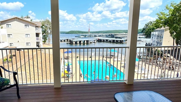 Een balkon met uitzicht op een zwembad en een steiger.