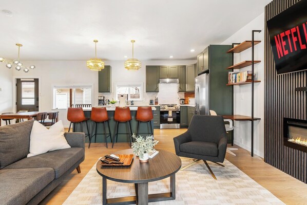 A modern living room with a sofa, coffee table, and a fireplace.